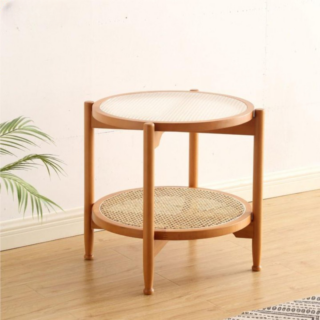 Table basse d'appoint japonaise en rotin présentée seule devant un mur blanc près d'une plante