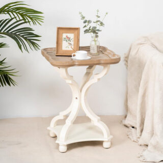 Table d'appoint carrée et vintage, avec un plateau couleur marron et des pieds vintage blanc, avec une plante posé dessus à côté d'un canapé