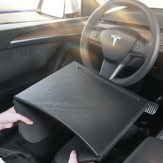 Table d'appoint pliante polyvalente noire en fibre de carbone sur fond d'intérieur de voiture