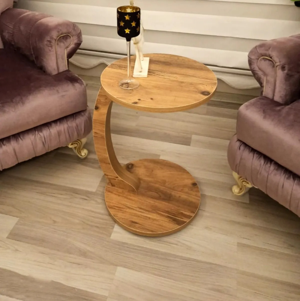 Table d'appoint moderne en forme de C en bois sur fond beige entre deux fauteuils