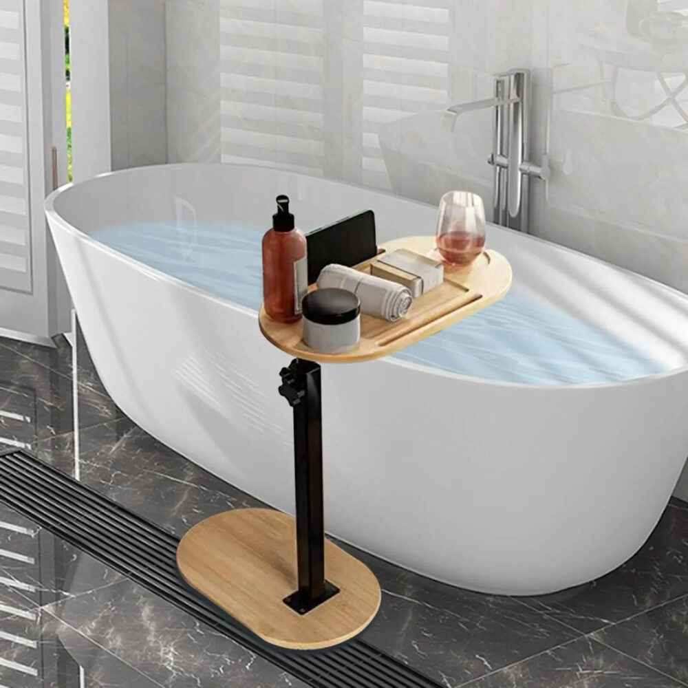 Table d'appoint réglable pour baignoire, avec support oval en bois, avec un poteau noir réglable positionné dessus et une tablette dessus au dessus d'une baignoire.